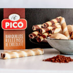 Barquillos rellenos de chocolate servidos en un cuenco, con cacao en polvo y la caja Picó detrás