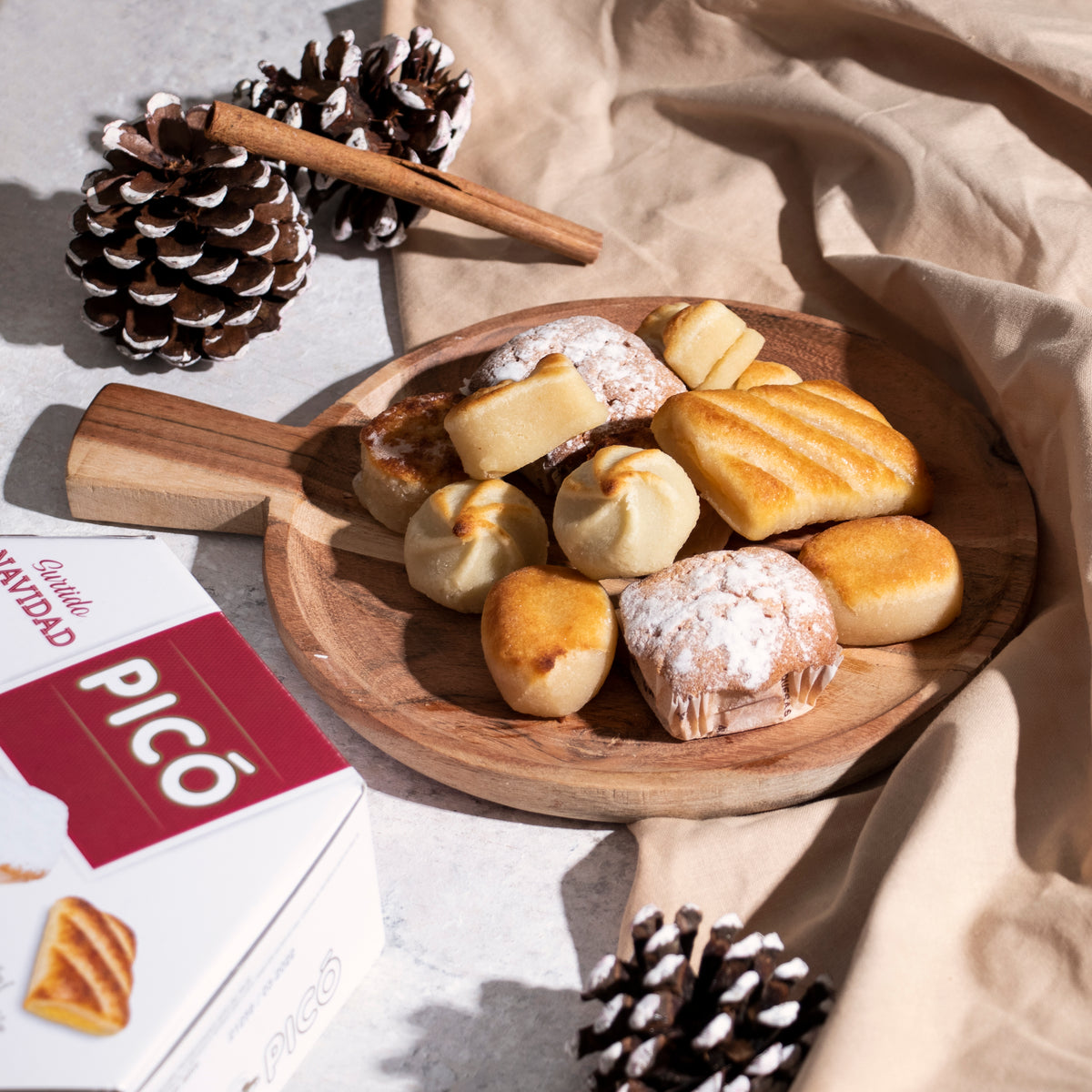 Surtido de Navidad Picó en una bandeja de madera: mazapanes, pasteles de gloria y de yema, con piñas