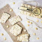 Turrón de Alicante hecho a mano partido en trozos sobre arpillera, con almendras peladas