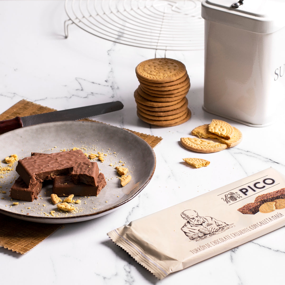Turrón de chocolate crujiente con galleta María en un plato, con galletas y su envase Picó