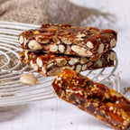 Trozos de turrón de guirlache con almendras y ajonjolí apilados sobre una rejilla
