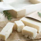 Dados de turrón de coco sobre arpillera, con una rama de abeto