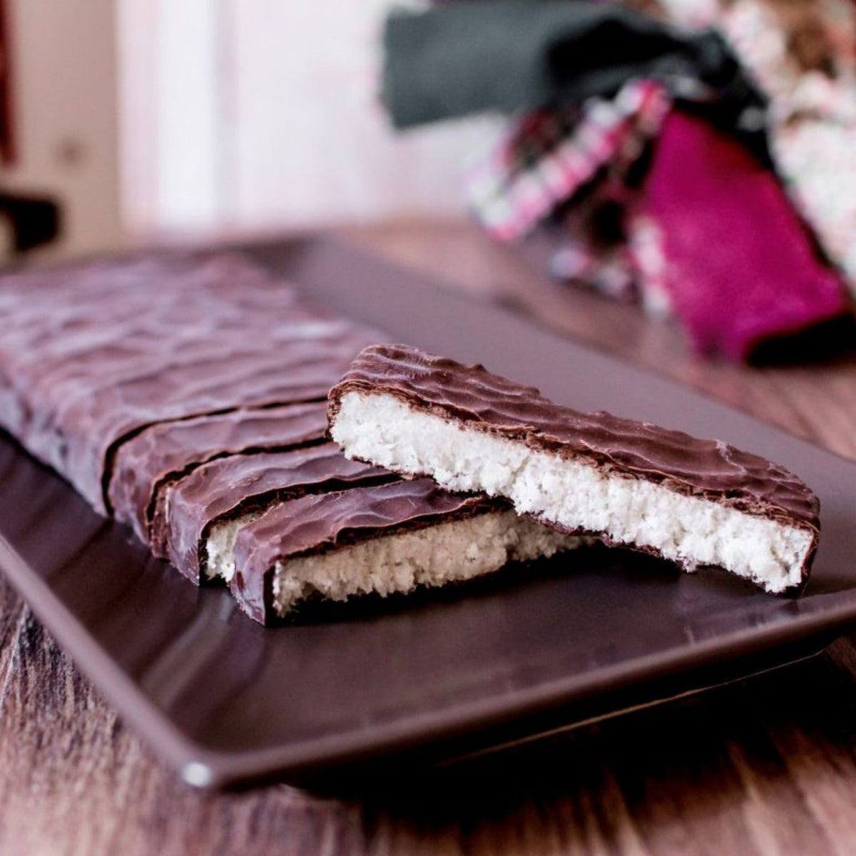 Turrón de coco bañado en chocolate cortado, mostrando el interior blanco de coco